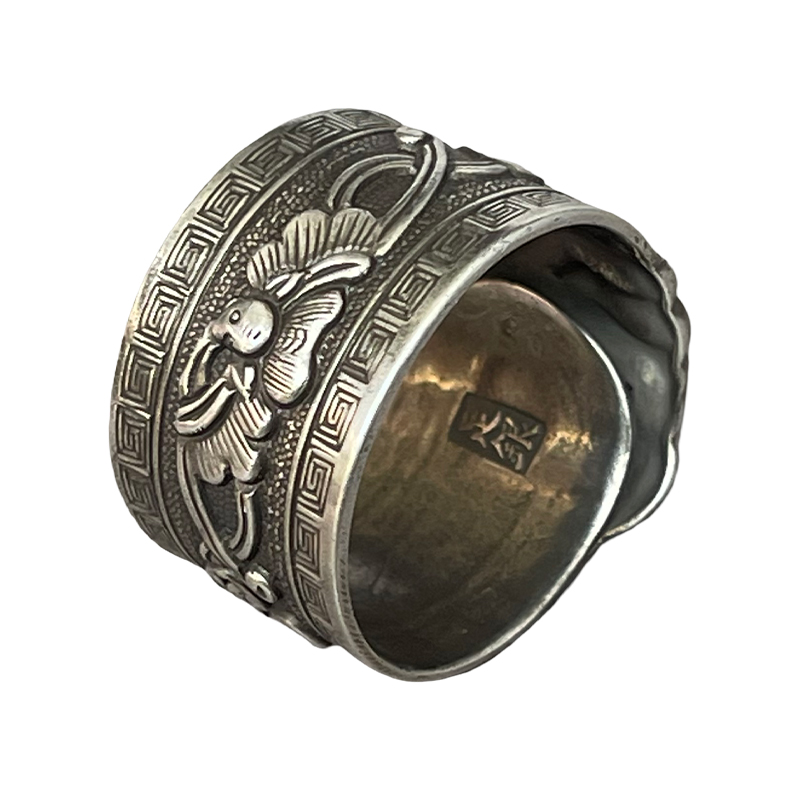 Lion Rolling Ball Engraved Silver Ring The "Lion Rolling an Embroidered Ball" is a classic auspicious pattern: the lion symbolizes majesty and protection, warding off evil and misfortune. The ball is no ordinary toy, it was a variation of the ancient Chinese saying "Taiping Youxiang" (meaning "peaceful and prosperous") or a "lucky object." Its rolling motion symbolizes "good fortune is coming," and the overall pattern conveys the auspicious wish of "warding off disasters, welcoming blessings, a smooth life, and prosperity and good fortune." The curling ring pictured above is made of S990 fine silver, weighing approximately 9.4g and measuring approximately 17.4mm wide. This vintage silver curling ring features a core craftsmanship element: the "rolling" element. Through hammering, curling, and shaping the silver, a smooth, linear texture is achieved. Combined with the three-dimensional engraving of the "Lion Rolling an Embroidered Ball," the lion's mane and the texture of the ball are distinctly layered. The ring combines the matte finish of vintage silver jewelry with the refined details of traditional patterns, embodying the fusion of traditional metal forging and engraving techniques.